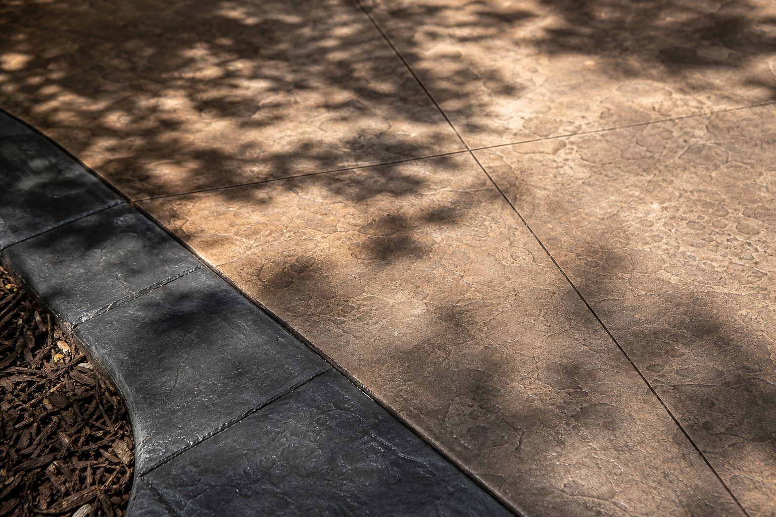 Close view of earth-toned stamped concrete with a dark border